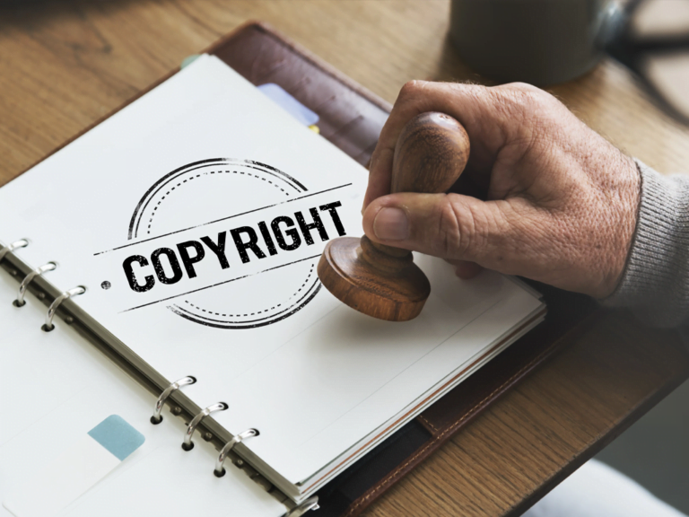 Mão carimba a palavra copyright em uma folha de fichário